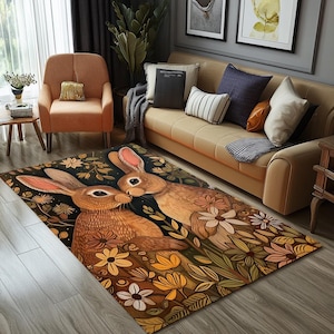 Könnte beinhalten: Ein brauner und beiger Teppich mit einem floralen Muster, das zwei braune Kaninchen mit langen Ohren zeigt. Die Kaninchen schauen sich an und scheinen sich zu küssen. Der Teppich hat einen dunkelbraunen Hintergrund mit gelben, weißen und grünen Blumen.