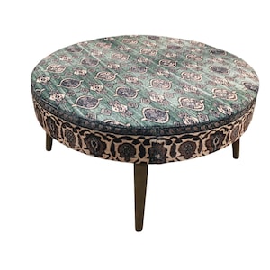 a round table with a patterned seat and legs.