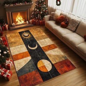 Puede incluir: Una alfombra rectangular con un diseño geométrico que presenta un sol, una luna y estrellas en tonos naranja, amarillo, marrón y azul sobre un fondo negro.