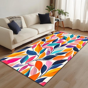 May include: A colourful area rug with a white background and a pattern of orange, pink, blue, and green leaves. The rug is on a wooden floor in front of a white sofa.