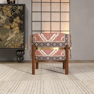 a modern living room with a patterned chair, a decorative cabinet, and a large window with a white frame.