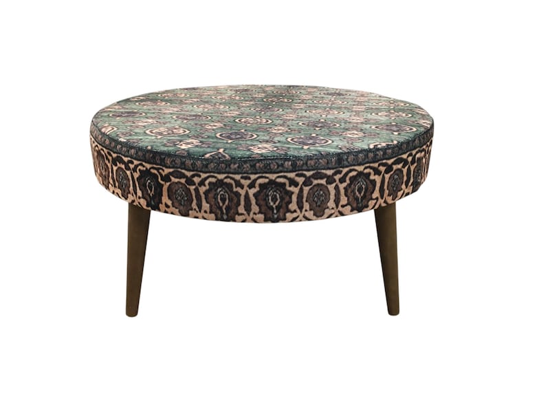 a round table with a patterned top and two wooden legs.