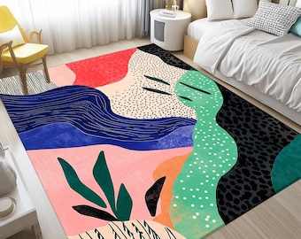 May include: A colorful area rug with an abstract design. The rug features a mix of shapes and colors, including red, blue, pink, green, and black. The design includes dotted patterns, wavy lines, and leaf-like shapes. The rug is placed in a bedroom setting.