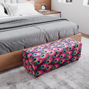 a bedroom with a bed, a wooden headboard, and a colorful patterned ottoman placed on the floor.