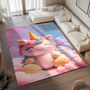 Op de afbeelding: Een roze en wit pluche eenhoorn speelgoed met een regenboog manen en staart, zittend op een roze en wit wolkenachtig kleed. Het kleed heeft een lichtblauwe achtergrond met verspreide sterren.