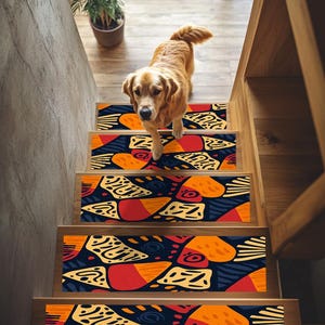 Puede incluir: Un conjunto de cuatro peldaños de escalera coloridos con un patrón geométrico en tonos naranja, amarillo, rojo y azul. Los peldaños están colocados en escaleras de madera.