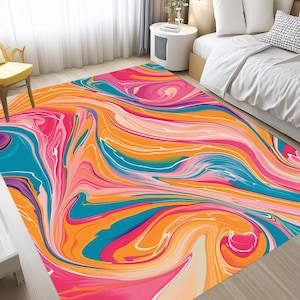 Puede incluir: Alfombra de área abstracta con un patrón de remolino de naranja, rosa, azul y blanco. La alfombra tiene un diseño moderno y abstracto.