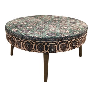 a round table with a patterned seat and four legs.