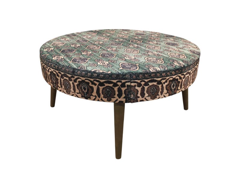 a round table with a patterned seat and four legs.