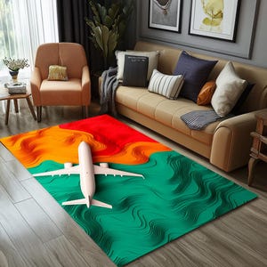 Può includere: Un tappeto astratto verde, arancione e rosso con un design di aereo bianco. Il tappeto ha un motivo ondulato e stratificato.
