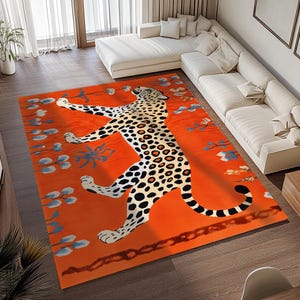 Puede incluir: Una alfombra naranja con un diseño de estampado de leopardo en blanco y negro. La alfombra presenta un leopardo estilizado con una cola larga y detalles intrincados.