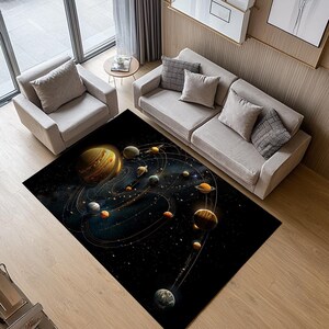 May include: A black and gold area rug with a space theme. The rug features a dark blue background with a depiction of planets and stars. The planets are in various shades of yellow, orange, red, and brown. The rug is perfect for adding a touch of whimsy and wonder to any room.
