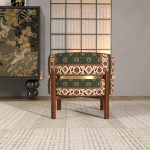 a modern living room with a green and gold patterned chair, a wooden side table, and a large window with a black and white patterned screen.