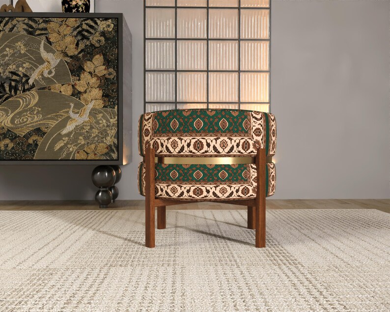 a modern living room with a green and gold patterned chair, a wooden side table, and a large window with a black and white patterned screen.