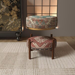 a modern living room with a rug, a wooden ottoman, and a large wall art piece.
