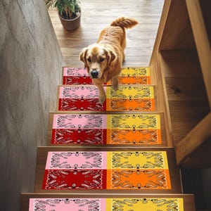 Könnte beinhalten: Ein Golden Retriever-Hund geht eine Holztreppe mit farbenfrohen Stufen hinunter. Die Stufen zeigen ein Bandana-Muster in Rot, Rosa, Gelb und Orange. Eine Topfpflanze ist oben auf der Treppe zu sehen.