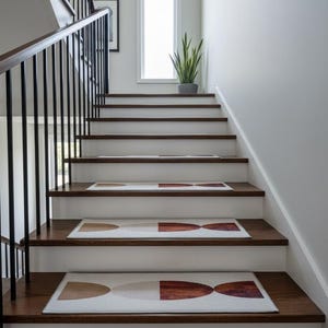 Può includere: Una scala in legno con gradini scuri e alzatine bianche. I gradini presentano tappeti rettangolari con un design geometrico beige, bianco e ruggine. Una ringhiera in metallo nero corre lungo il lato.