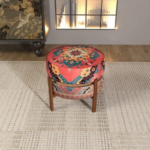 a vibrant, colorful ottoman with a patterned design, placed on a beige rug in a room with a fireplace and a bookshelf.