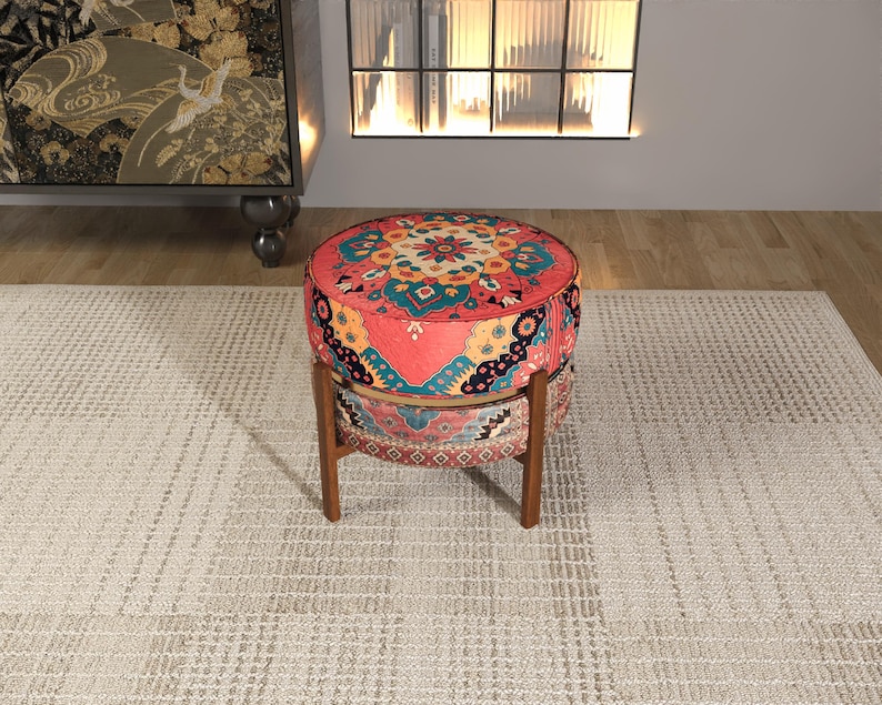a vibrant, colorful ottoman with a patterned design, placed on a beige rug in a room with a fireplace and a bookshelf.