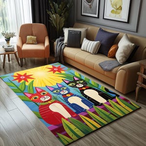 May include: A colorful rug with a blue background features three cartoon cats with different colored fur and collars. The cats are surrounded by green leaves and flowers. The rug has a yellow sun in the background.