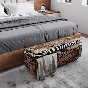 May include: A wooden bed frame with a gray comforter and pillows. A bench with a patterned top and storage is at the foot of the bed. The bench has a zebra stripe, leopard print, and tropical leaf design. A gray blanket is draped over the bench.
