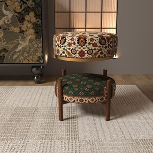 a modern living room with a rug, a decorative ottoman, and a large wall art piece.