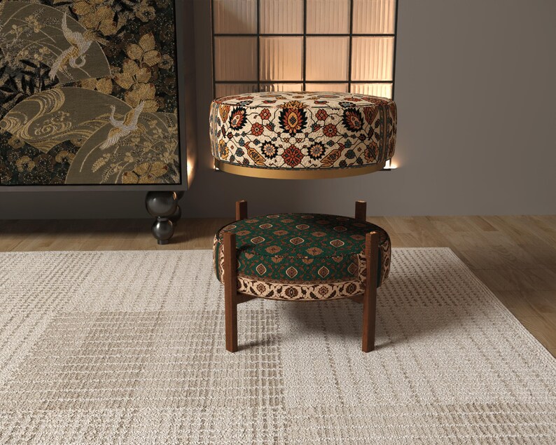 a modern living room with a rug, a decorative ottoman, and a large wall art piece.