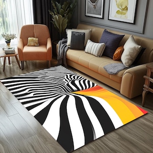 Könnte beinhalten: Ein schwarz-weiß gestreifter Teppich mit einem gelben und orangefarbenen Wirbelmuster. Der Teppich liegt auf einem Holzboden vor einer Couch.