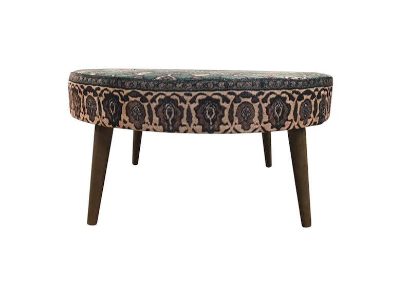 a round table with a patterned seat and four wooden legs.