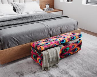 May include: A colorful storage bench with a peacock feather design sits at the foot of a bed. The bench is open, revealing a blanket and pillows. The bed has a gray comforter and white pillows. The bench is approximately 40 inches long.