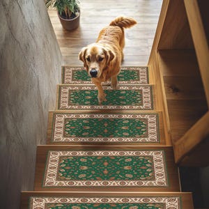 以下が含まれることがあります： ゴールデンレトリバーの犬が、緑とベージュの模様の階段マットが付いた木製の階段を降りています。階段マットは花柄のデザインと装飾的な縁取りが施されています。階段の上には鉢植えの植物が見えます。