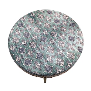 a round table with a patterned seat cover.