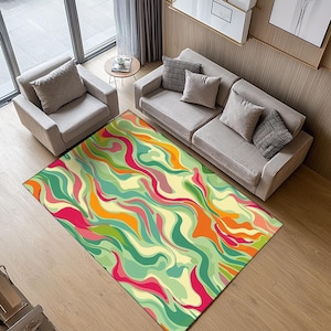 Könnte beinhalten: Abstrakter Teppich mit einem wirbelnden Muster in Grün, Orange, Rot und Weiß. Der Teppich liegt auf einem Holzboden in einem Wohnzimmer.