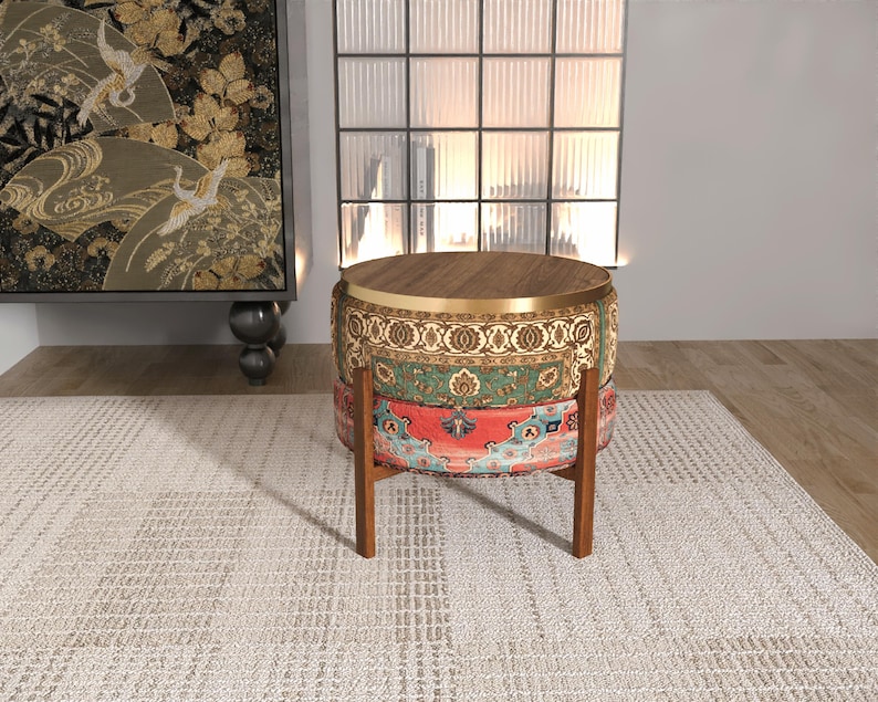 a decorative table with a wooden top and a colorful, patterned base, placed on a white rug in a room with a large window and a painting on the wall.