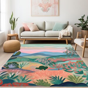 Könnte beinhalten: Ein farbenfroher abstrakter Teppich mit einem Landschaftsdesign in Grün-, Blau-, Rosa- und Orangetönen. Der Teppich zeigt eine stilisierte Bergkette mit Bäumen und Blumen im Vordergrund.