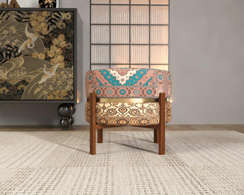 a colorful, patterned chair with a wooden frame, placed on a white rug in a room with a large window and a decorative wall.