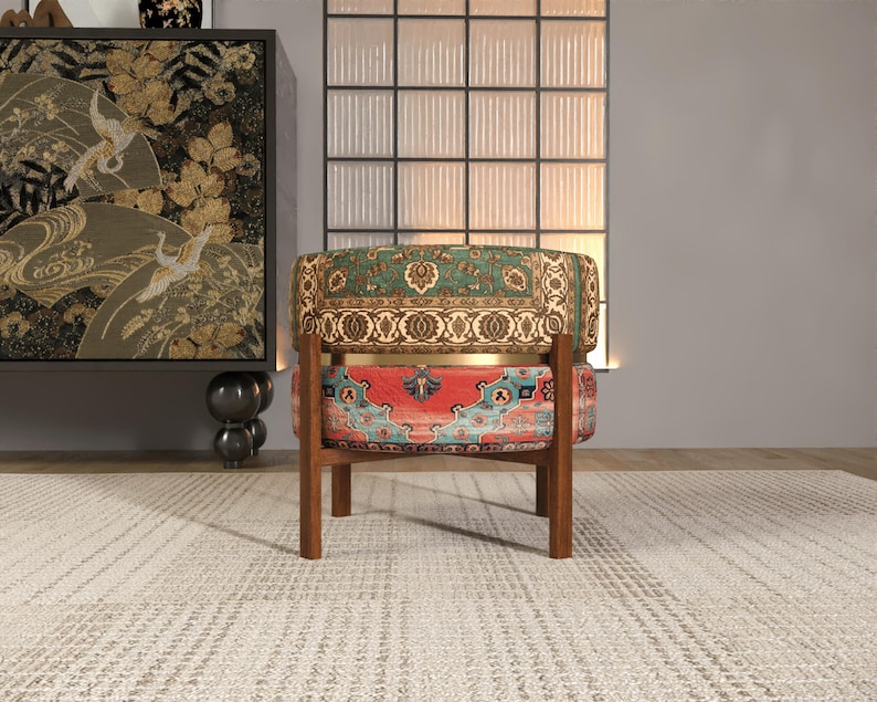 a colorful, patterned chair with a wooden frame, placed in a room with a large window and a decorative cabinet.