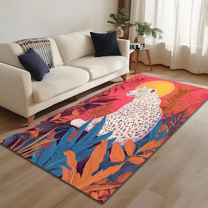 Op de afbeelding: Een kleurrijk tapijt met een wit luipaardprintontwerp, met een groot oranje blad en een roze achtergrond. Het tapijt ligt op een houten vloer voor een witte bank.