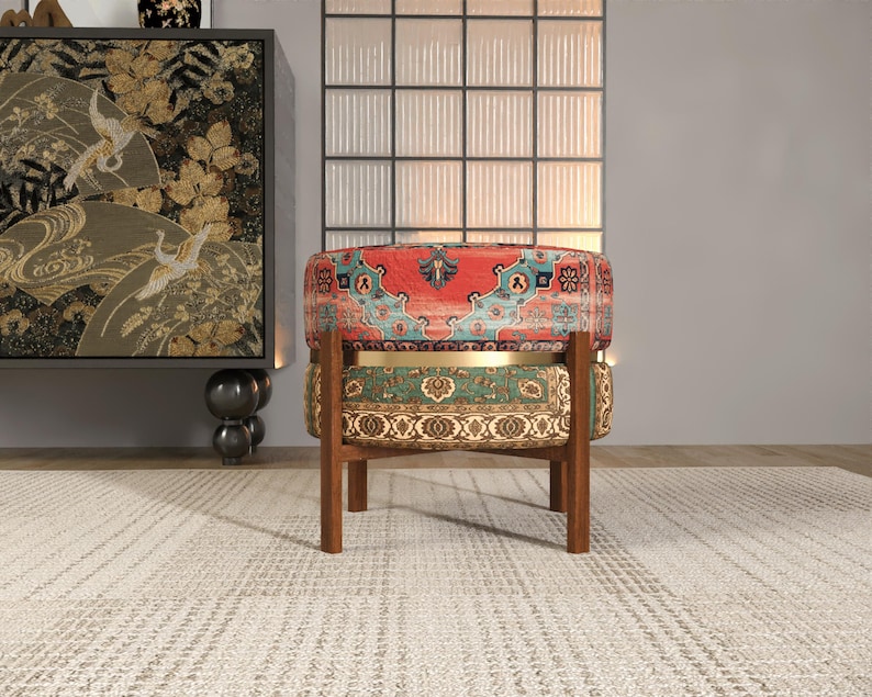 a vibrant, multi-colored chair with a patterned seat and backrest, placed on a white rug in a room with a large window and a black and gold cabinet.