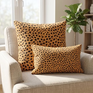 May include: Two decorative throw pillows featuring a repeating cheetah print pattern in shades of tan, brown, and black. One pillow is square-shaped, and the other is rectangular, both displaying a consistent spotted animal fur design.