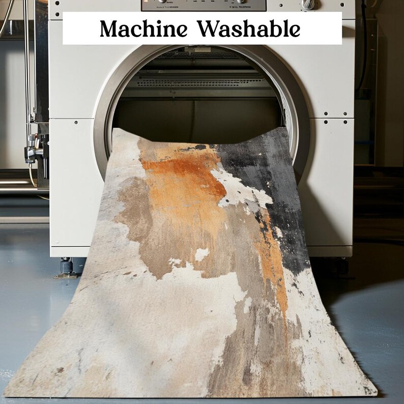 May include: A white washing machine with the words "Machine Washable" on the front. A large, abstract patterned rug is being fed into the machine.
