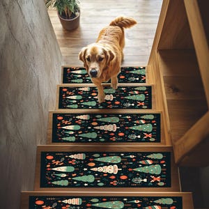 May include: A set of five Christmas tree patterned non-slip stair treads. The treads are black with green, red, and white Christmas trees and ornaments. A golden retriever dog is standing on the stairs.