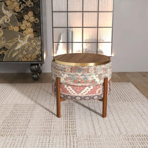 a modern, multi-colored ottoman with a wooden top, placed on a white rug in a minimalist living room setting.