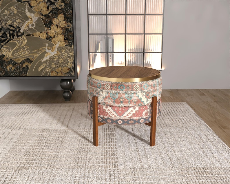a modern, multi-colored ottoman with a wooden top, placed on a white rug in a minimalist living room setting.