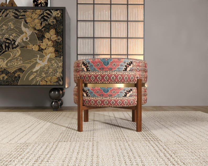 a vibrant, patterned chair with a wooden frame, placed on a white rug in a room with a large window and a decorative cabinet.