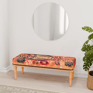 May include: A wooden bench with a colorful tiger print fabric seat. The bench has a simple design with four legs and a rectangular seat. The fabric features a tiger pattern with orange, red, black, and white colors.