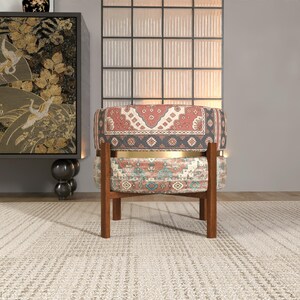 a chair with a colorful, patterned cushion, placed in front of a large, ornate wall decoration.