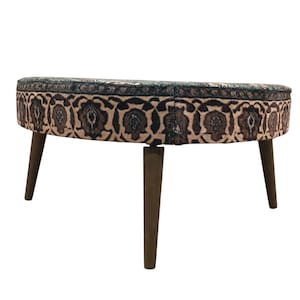 A round ottoman with a patterned seat and wooden legs.