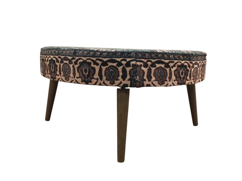 A round ottoman with a patterned seat and wooden legs.