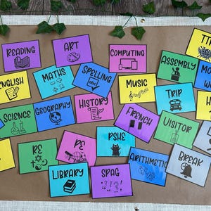 Peut inclure: Ensemble de cartes de matières scolaires colorées, avec "Lecture", "Art", "Maths" et "Anglais". Chaque carte présente un titre de matière et une icône, disposées sur une surface marron avec des éléments décoratifs.